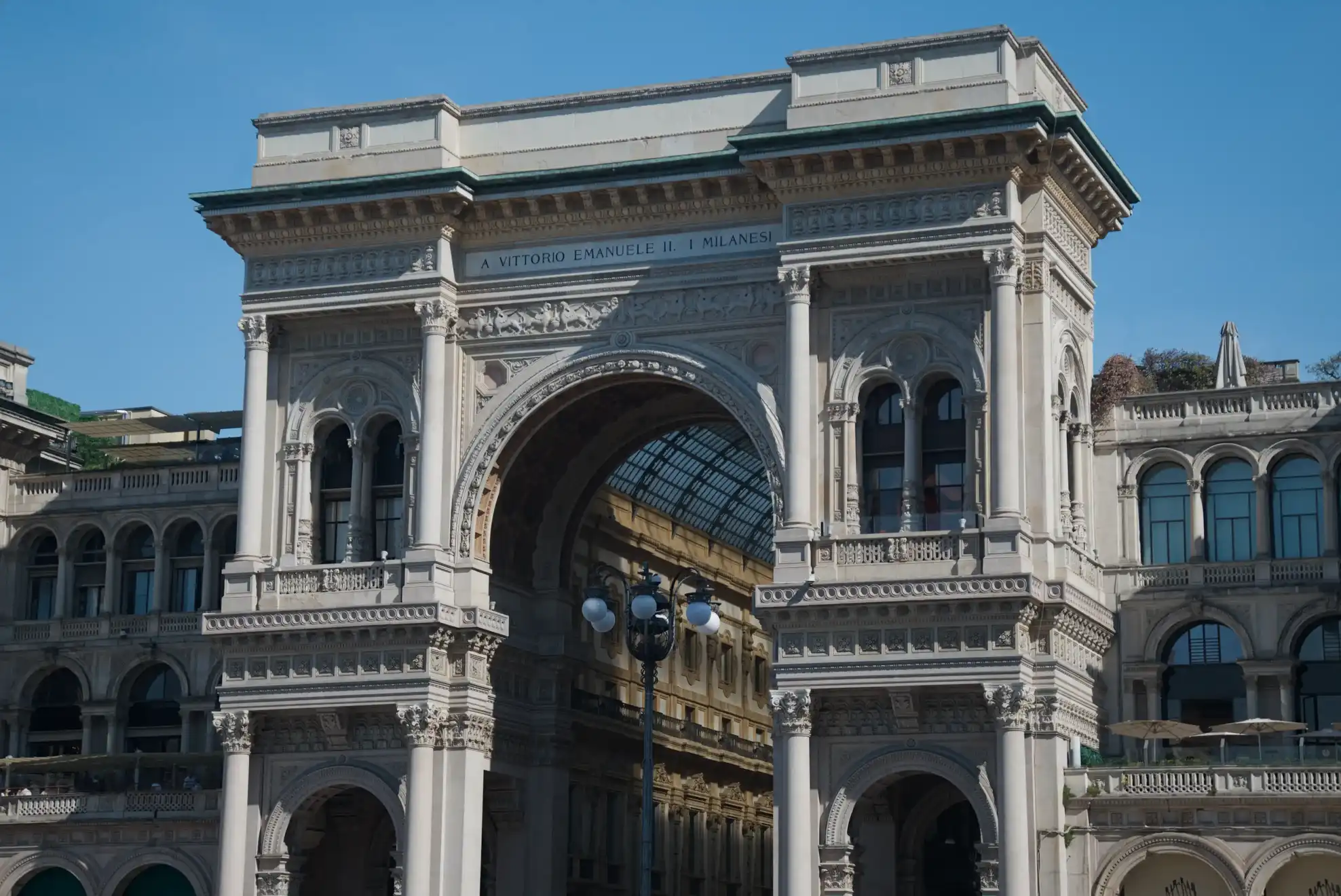 Façade monumentale de la galerie Vittorio Emanuele II à Milan, avec son arche ornée et son architecture néoclassique